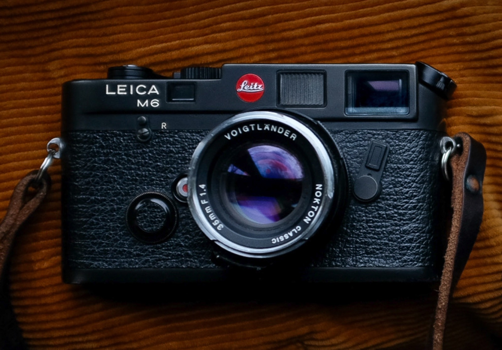 A film camera and rolls of 35mm film on a workbench
